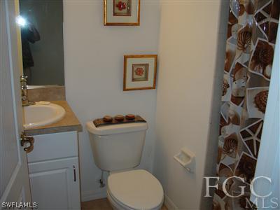 2134 Armour Road Lehigh Acres, FL 33973 - Photo 1 of 10 a white toilet sitting next to a bathroom sink