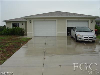 2134 Armour Road Lehigh Acres, FL 33973 - Photo 5 of 10 a car parked in front of white house