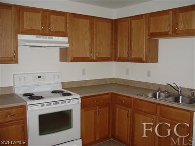 2134 Armour Road Lehigh Acres, FL 33973 - Photo 6 of 10 a kitchen with granite countertop cabinets and white stove