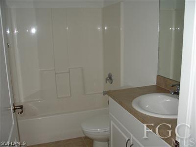 2134 Armour Road Lehigh Acres, FL 33973 - Photo 7 of 10 a bathroom with a sink a toilet and shower