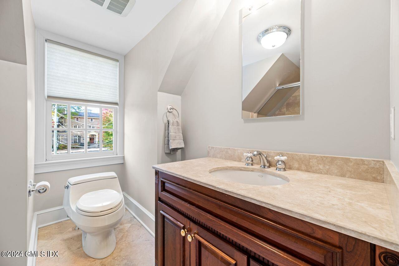 43 Maple Avenue, Unit 2 Greenwich, CT 06830 - Photo 10 of 17 a bathroom with a granite countertop sink a toilet and a large mirror