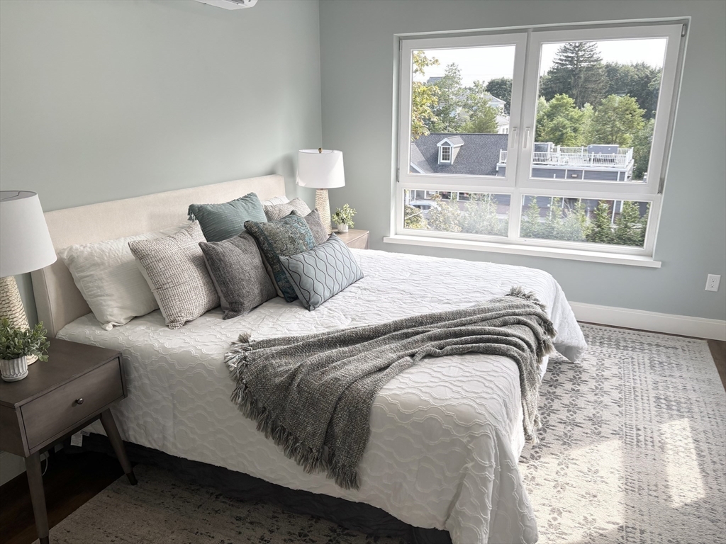 1391 Main Street, Unit 208 Walpole, MA 02081 - Photo 23 of 36 a bedroom with a bed and a large window