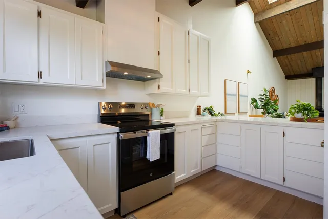 a kitchen with white cabinets and white appliances