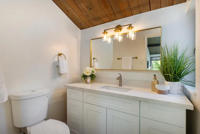 a bathroom with a toilet sink and mirror