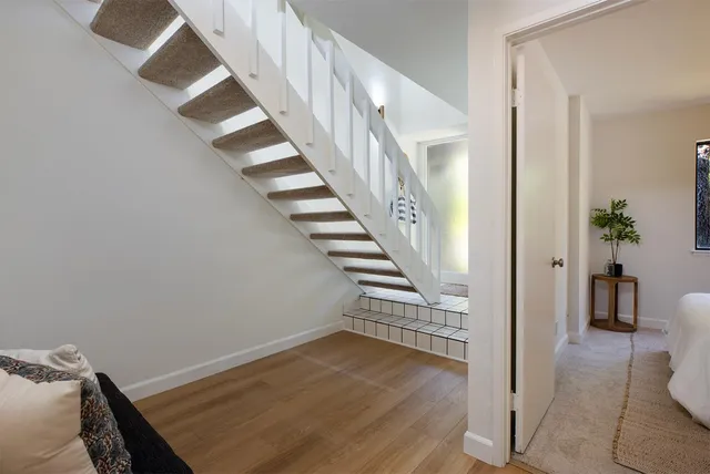 a view of a hallway with wooden floor and entryway