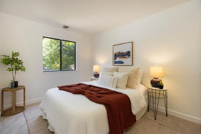 a bedroom with a bed and a potted plant