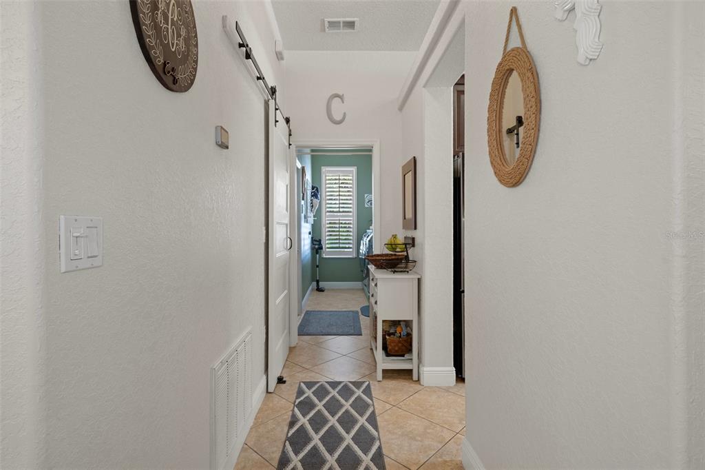 12403 Moneta Road Weeki Wachee, FL 34614 - Photo 35 of 56 Hallway to pantry, kitchen entrance on right, laundry room, interior garage door in laundry room