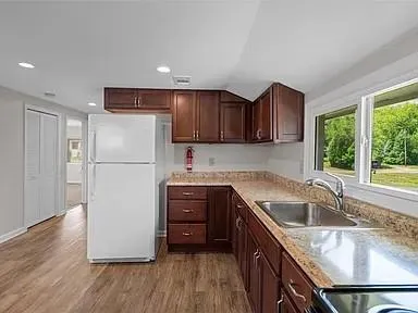 a kitchen with stainless steel appliances a sink cabinets and a wooden floor