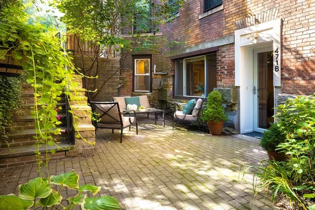 a view of a house with backyard and sitting area