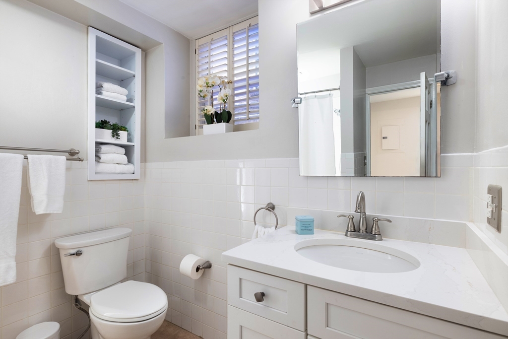 471 Washington Street, Unit B Brookline, MA 02446 - Photo 8 of 10 a bathroom with a toilet a sink and mirror