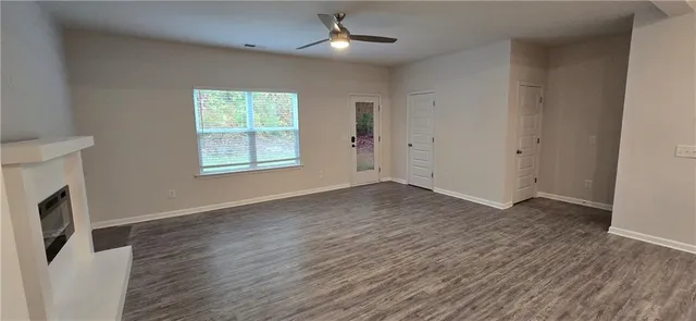 a view of an empty room and wooden floor and a window