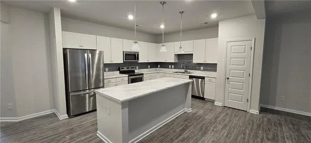 a kitchen with white cabinets stainless steel appliances and sink