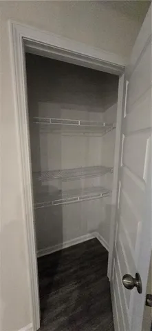 an empty room with wooden floor a ceiling fan and windows