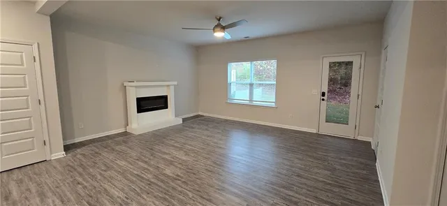 a view of a livingroom with wooden floor and a fireplace