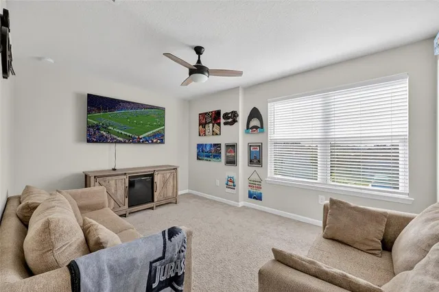 a living room with furniture and a ceiling fan