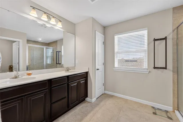 a spacious bathroom with a double vanity sink and mirror