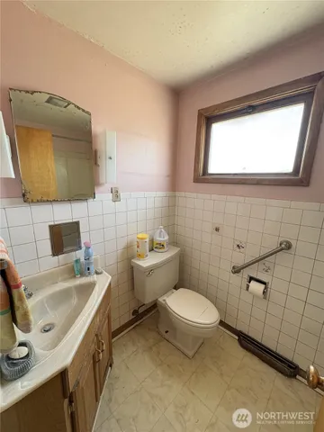 a bathroom with a toilet sink and mirror