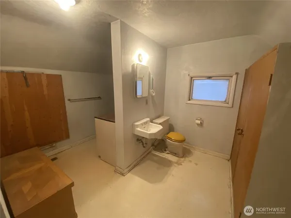 a bathroom with a sink a toilet a rug and shower curtain