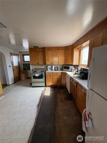 a kitchen with stainless steel appliances granite countertop a stove sink refrigerator and cabinets