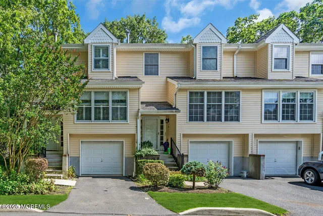 a front view of a house with a yard and potted plants