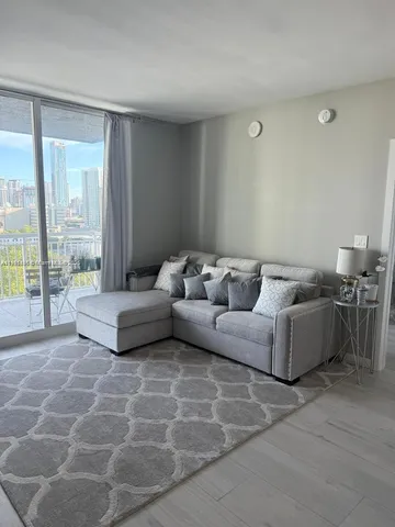 a living room with furniture and a floor to ceiling window