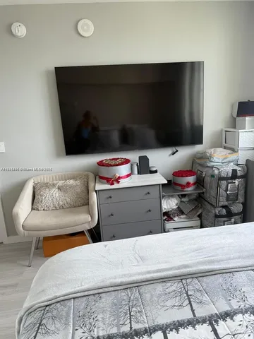 a bedroom with furniture and a flat screen tv