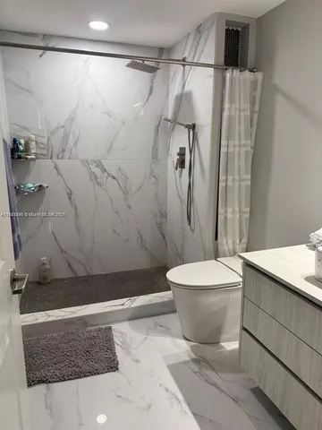 a bathroom with a toilet and a shower