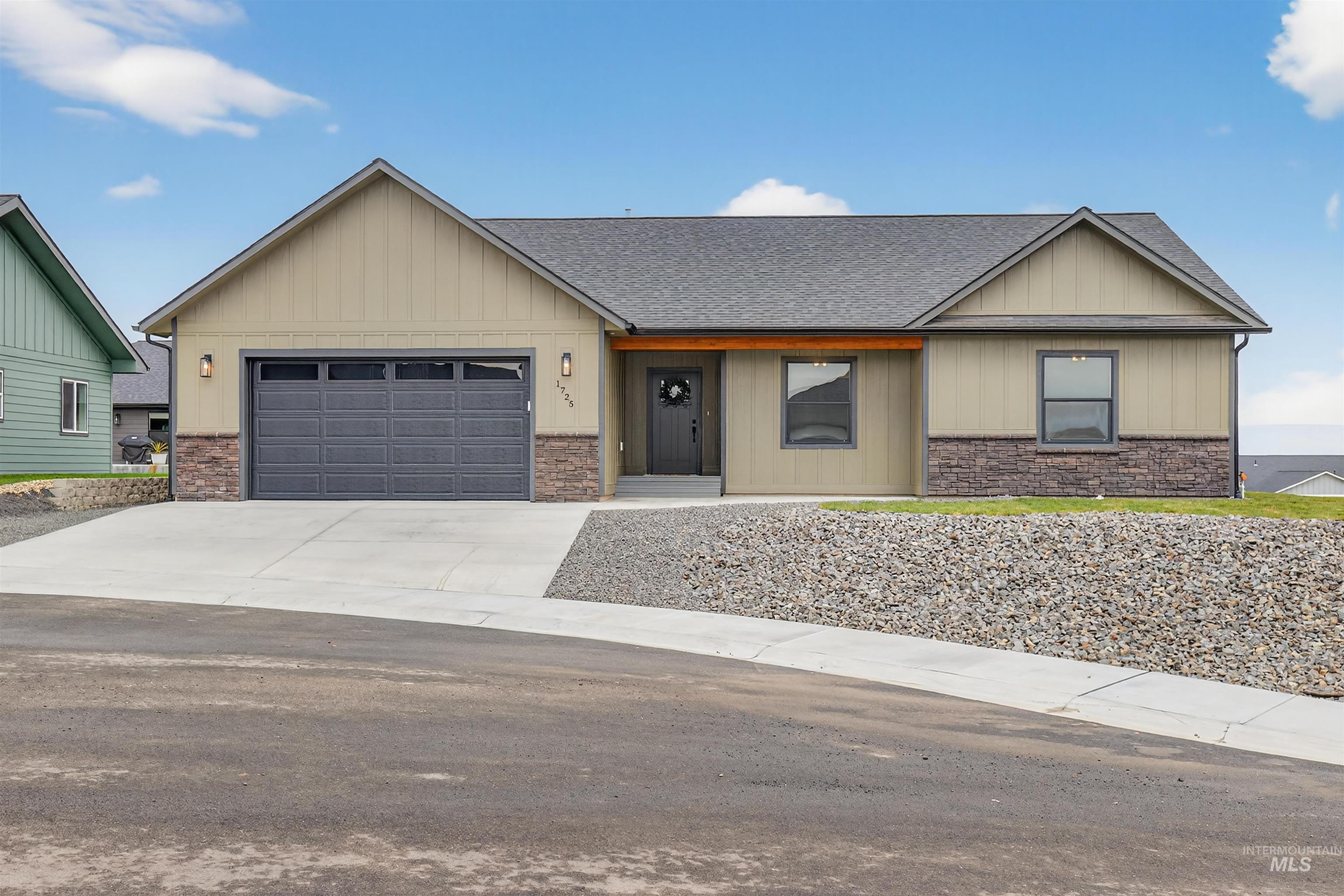 1725 Pathway Court Lewiston, ID 83501 - Photo 2 of 37 View of front of property featuring roof with shingles, concrete driveway, board and batten siding, an attached garage, and stone siding