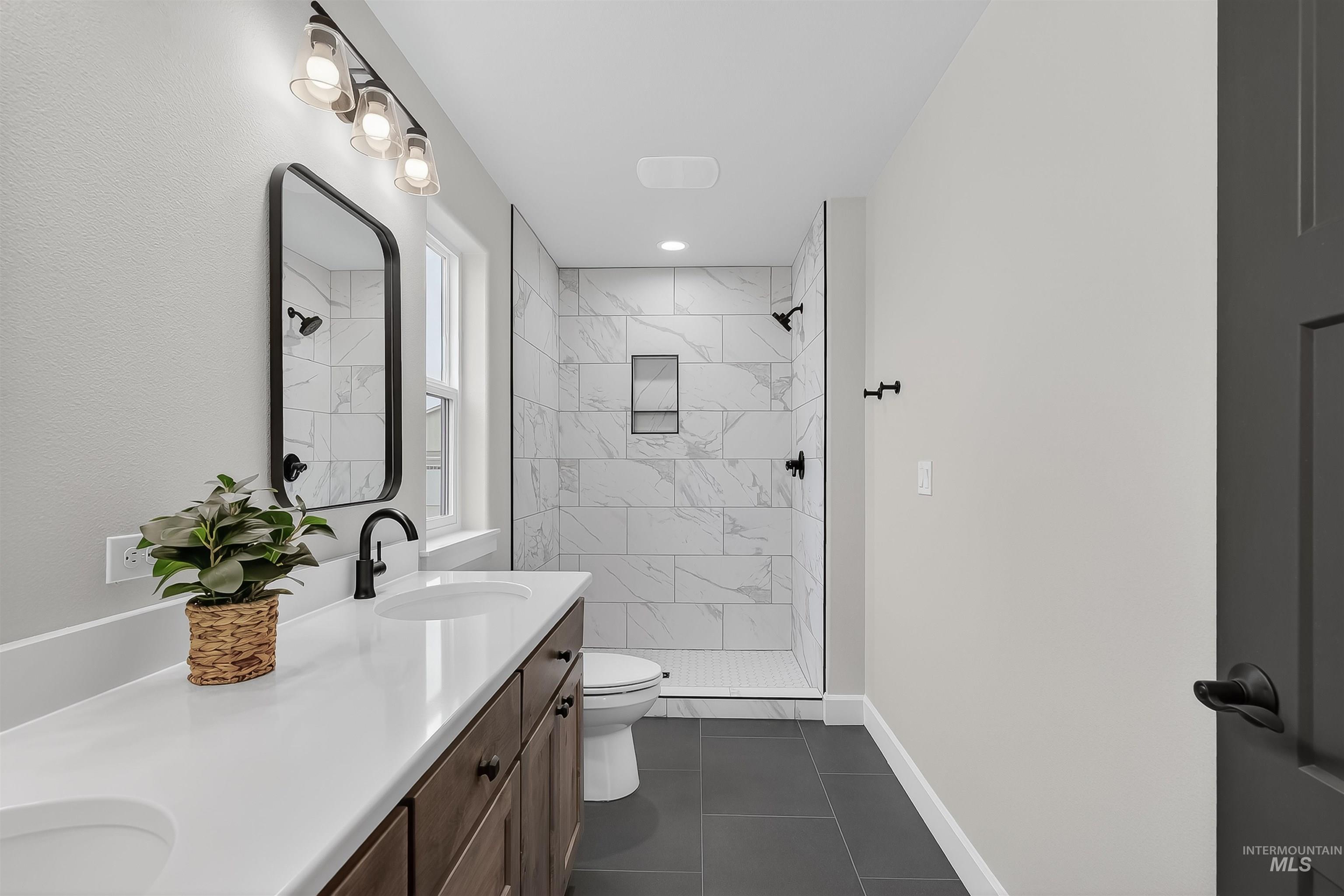 1725 Pathway Court Lewiston, ID 83501 - Photo 22 of 37 Full bathroom with double vanity, a marble finish shower, and dark tile patterned flooring