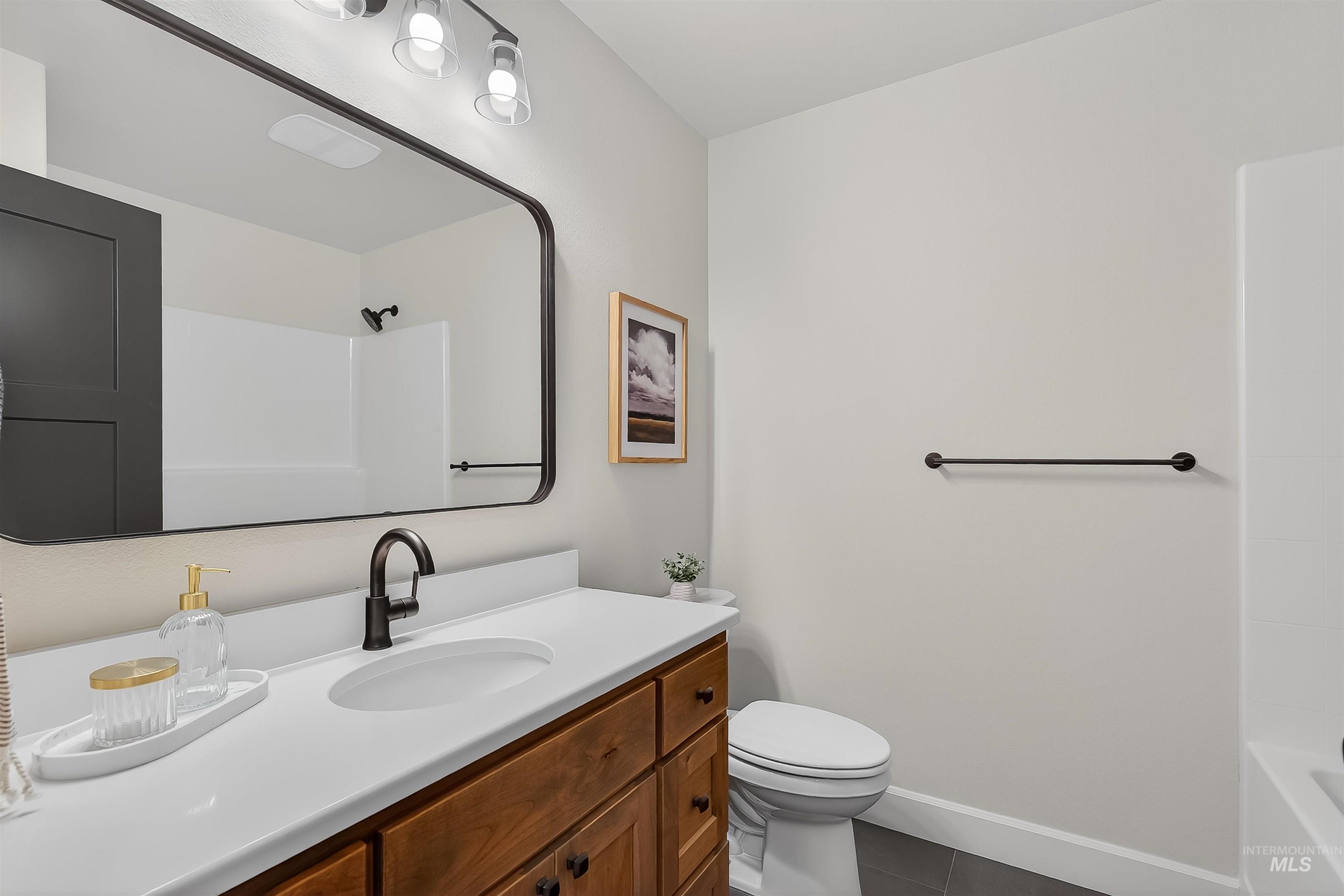 1725 Pathway Court Lewiston, ID 83501 - Photo 27 of 37 Bathroom with vanity, washtub / shower combination, and dark tile patterned floors