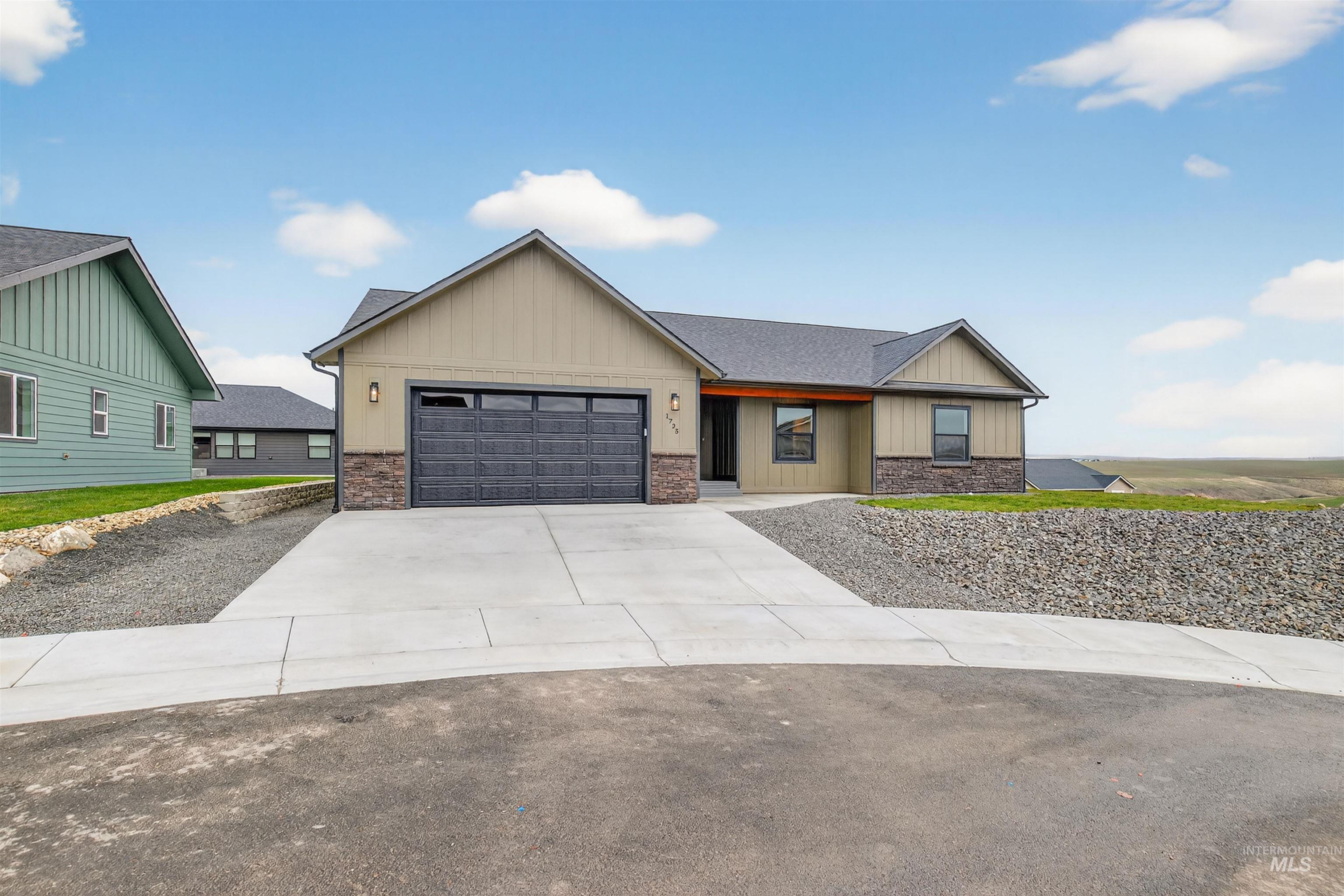 1725 Pathway Court Lewiston, ID 83501 - Photo 36 of 37 View of front facade featuring board and batten siding, driveway, an attached garage, and stone siding
