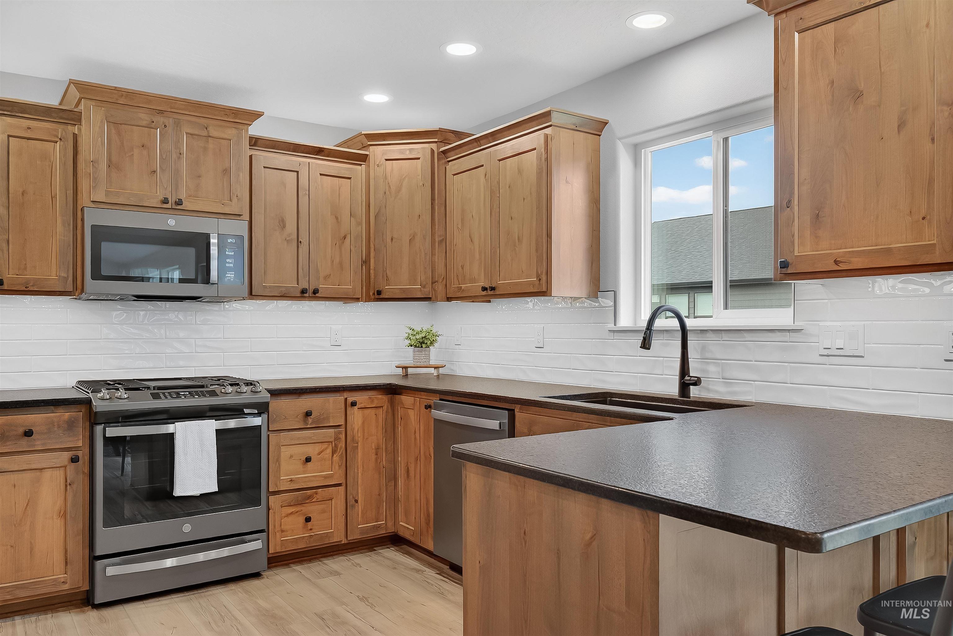 1725 Pathway Court Lewiston, ID 83501 - Photo 7 of 37 Kitchen with stainless steel appliances, tasteful backsplash, a peninsula, light wood-style floors, and recessed lighting