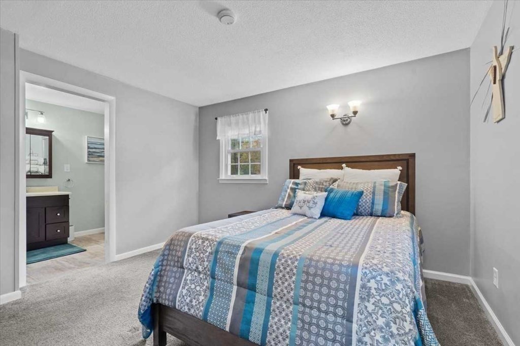 170 Shepard Road Sturbridge, MA 01566 - Photo 18 of 41 a bedroom with a large bed and a chandelier