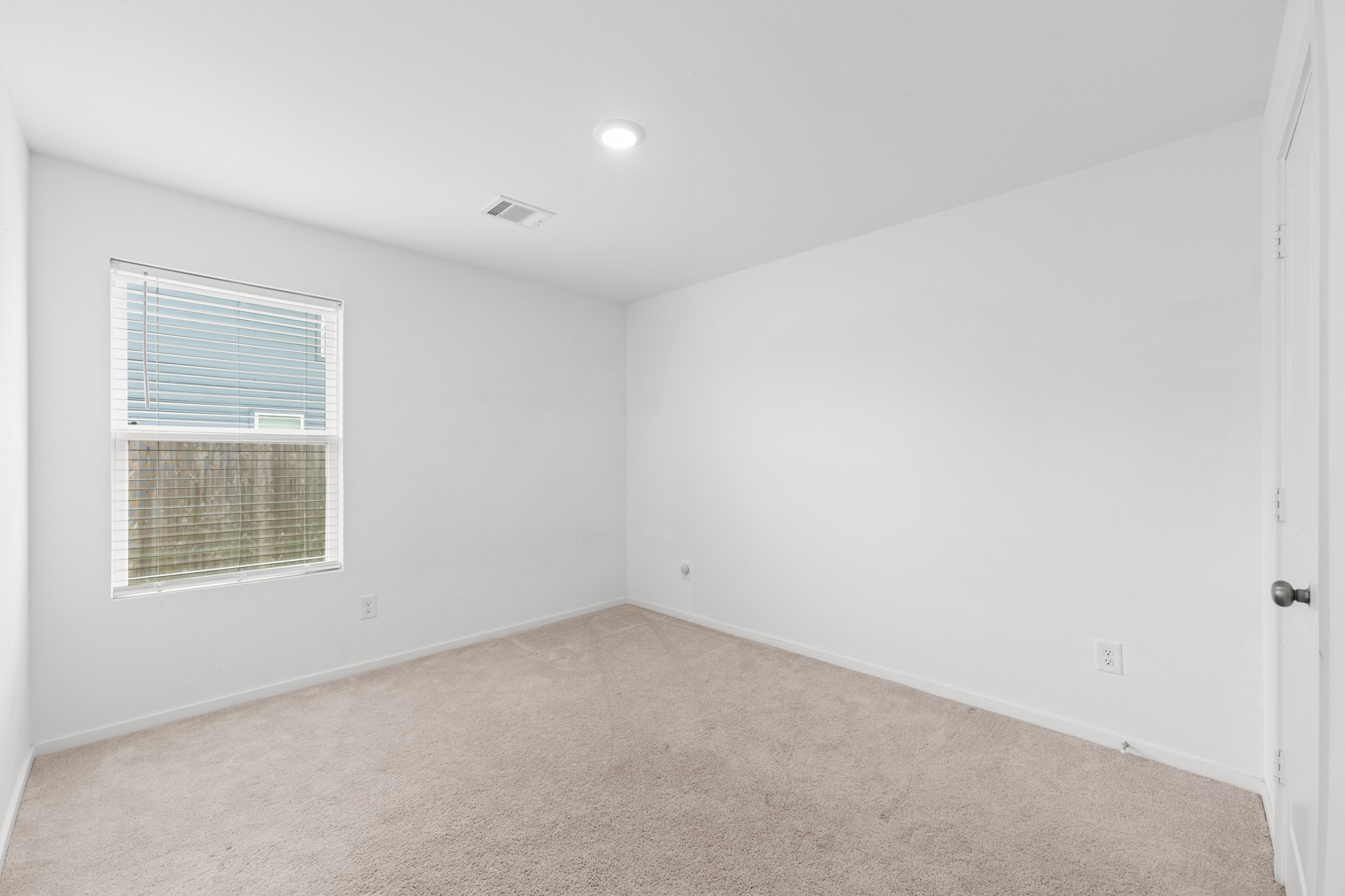 252 Houston Street Angleton, TX 77515 - Photo 32 of 49 Alternate view highlights the bedroom’s versatile layout, neutral carpeting, and ample wall space for furniture placement.
