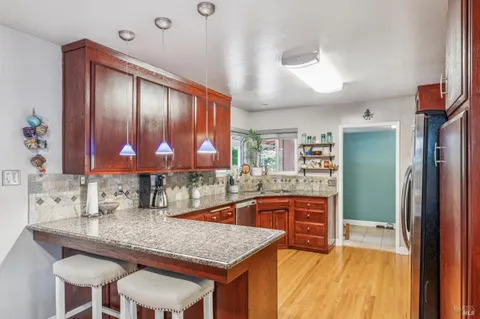a kitchen with stainless steel appliances kitchen island granite countertop a refrigerator a stove top oven and sink