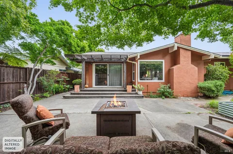 a view of backyard with table and chairs and a large tree