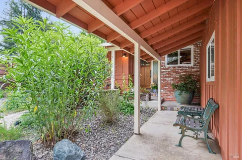a view of a porch with chairs and potted plants