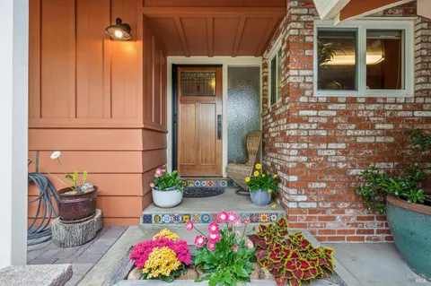 a vase of flowers sitting on a floor in front of a door