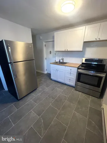 a kitchen with stainless steel appliances a sink a stove a refrigerator and cabinets
