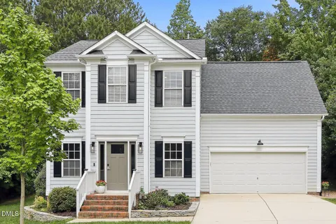 a view of a white house with large windows and large trees