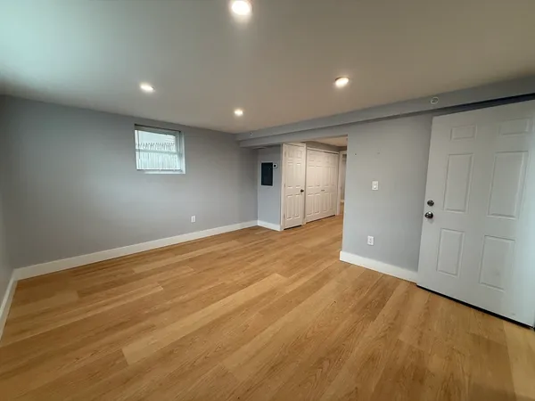 an empty room with wooden floor and white walls