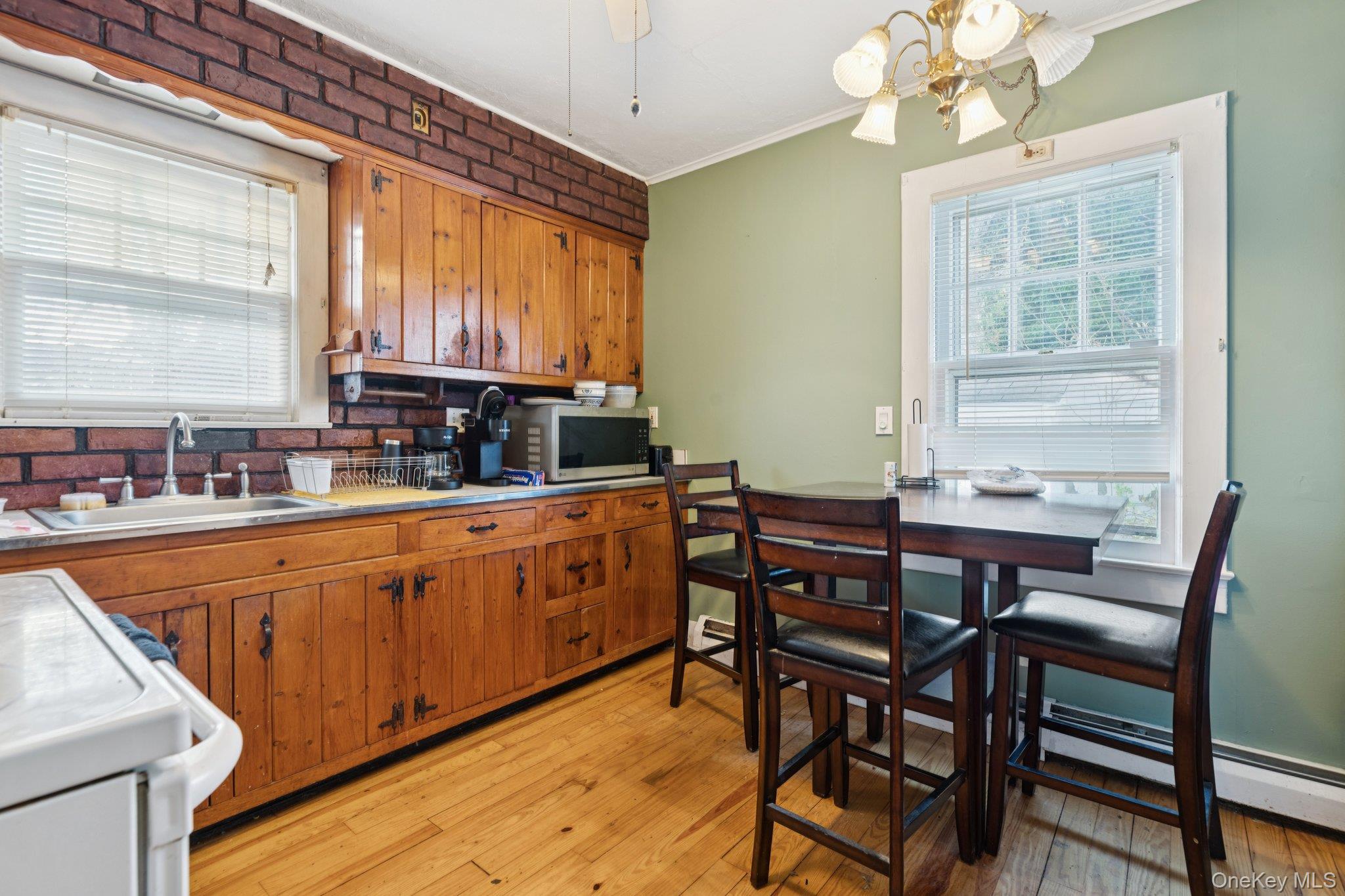 83 Elm Road East Mastic Beach, NY 11951 - Photo 7 of 34 a kitchen with stainless steel appliances granite countertop a table chairs sink and cabinets