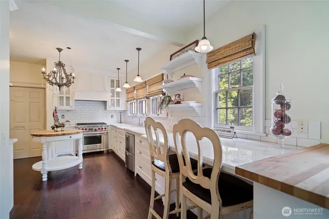 a view of a dining room and livingroom with furniture wooden floor a chandelier