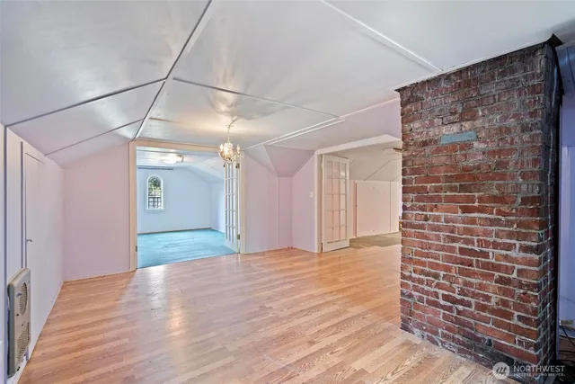 a view of an empty room with wooden floor