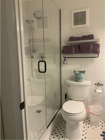 a bathroom with a toilet and a shower