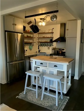 a kitchen with stainless steel appliances kitchen island granite countertop a refrigerator a stove and a sink