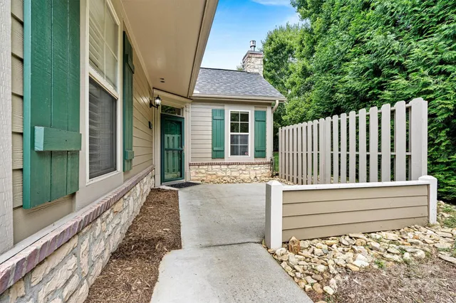a view of a house with a small yard and wooden floor and fence