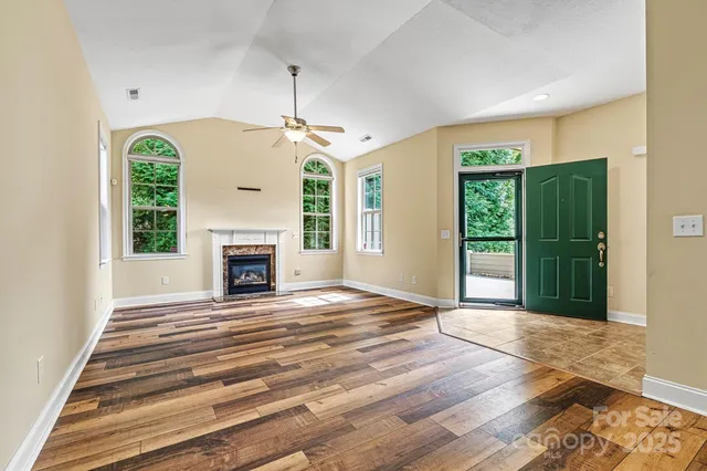 a view of an empty room with a fireplace and a window