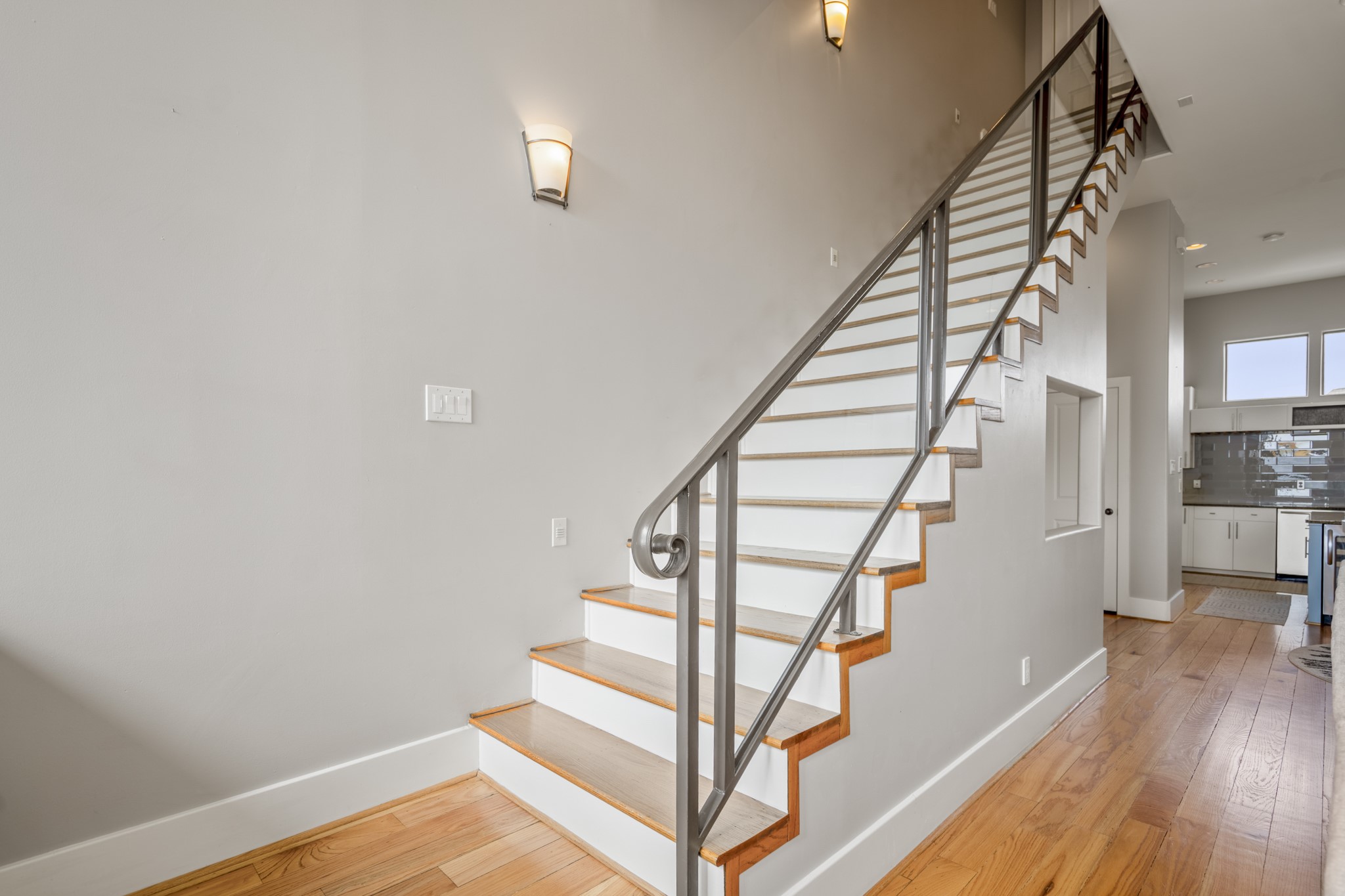 1310 West Dallas Street Houston, TX 77019 - Photo 27 of 50 This angle brings the staircase into focus, where warm wood treads and modern railing details create a strong architectural moment. It serves as a natural transition between levels while keeping the layout open and visually connected.
