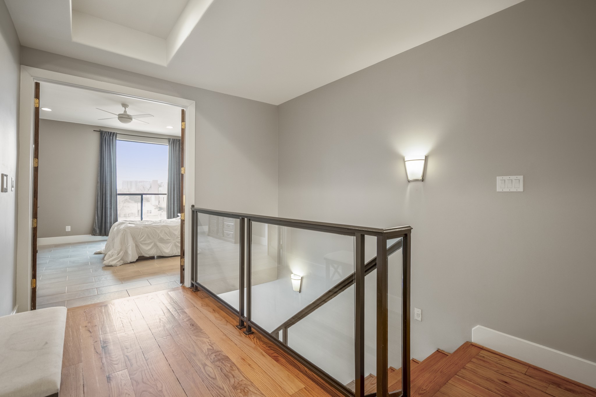 1310 West Dallas Street Houston, TX 77019 - Photo 28 of 50 This upper-level landing keeps the home feeling open and connected, with glass railing details that let light flow freely between levels. It creates an airy transition to the bedrooms while still offering a sense of separation and privacy.
